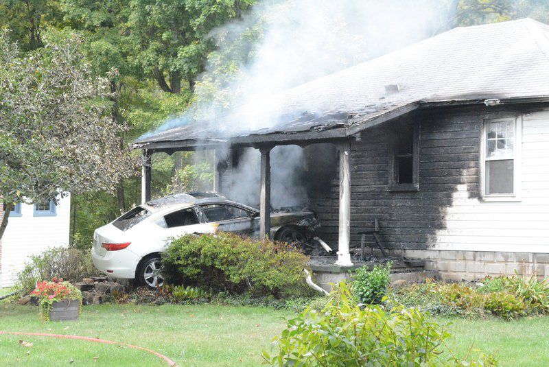 Fleeing vehicle hits house, catches fire